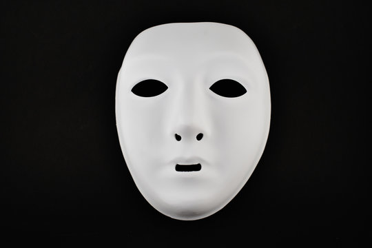 Plastic white face mask stock images. White mask on a black background. Plastic human mask