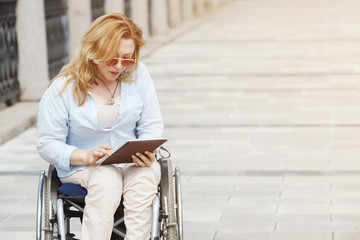 Woman in a wheelchair in the city park. The concept of an accessible environment for disabled...