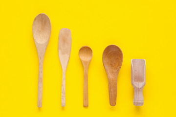 Wood spoon kitchenware on color background.