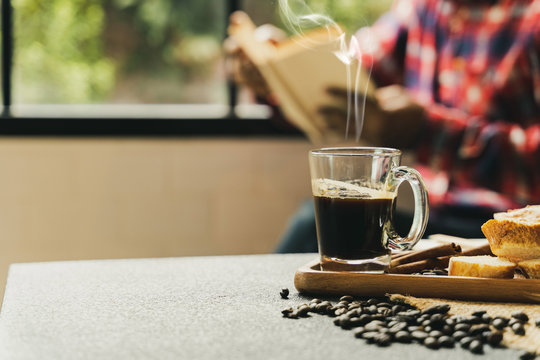 a coffee set on desk with people sit behind besie window.