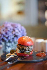 Burger. Wagyu beef burger with soft focus on the beef. Red buns with sesame.