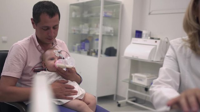 Baby in the arms of his father in the hospital