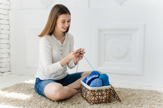 a woman knitting warm socks at home