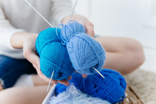 a woman knitting warm socks at home