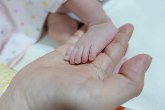 One hand holding foot of newborn