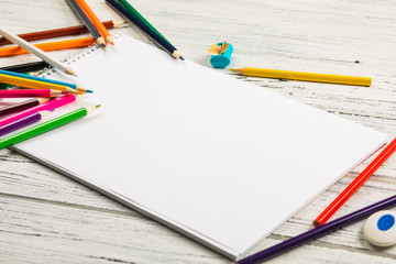 Art album and colored pencils on old wooden boards.