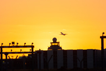 silhouette of plane leaving airport 
