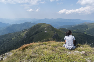 Fototapeta na wymiar Beautiful girl in the mountains. An incredible view of the Troyan Balkan. The mountain captivates with its beauty, fresh air, a sense of infinity, coziness and tranquility.