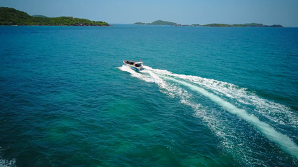 Naklejka premium Ferry at the Gulf of Siam. Aerial view of floating ferry at sunset. Colorful landscape with boat, turquoise sea. Top view from drone of yacht. Seascape with motorboat