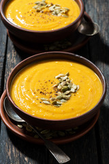 pumpkin soup on wooden table, vertical