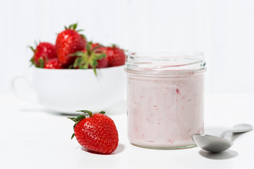sweet strawberry yogurt and fresh berries on a white table, closeup