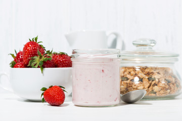 sweet strawberry yogurt, granola and fresh berries on white background