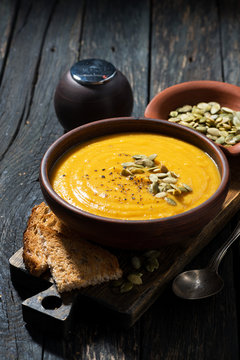 pumpkin soup with toasts on wooden table