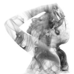 Double exposure portrait of a woman gently touching her hair and a smoky texture