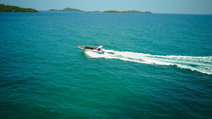 Naklejka premium Ferry at the Gulf of Siam. Aerial view of floating ferry at sunset. Colorful landscape with boat, turquoise sea. Top view from drone of yacht. Seascape with motorboat