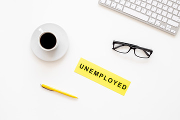 Unempoyed sign on office desk with computer keyboard on white background top view. Unemployment concept