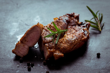 Grilled beef steak with spices on black Stone Table