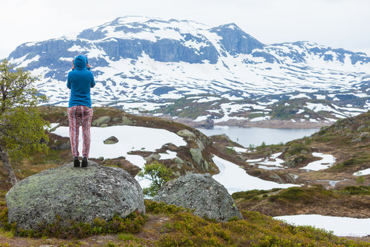 Tourist woman enjoying mountains landscape in Norway