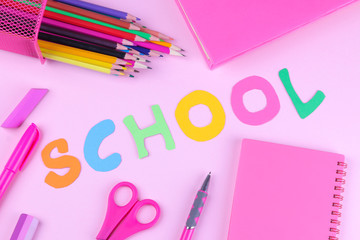 Pink school and office supplies with an inscription school on a bright pink background