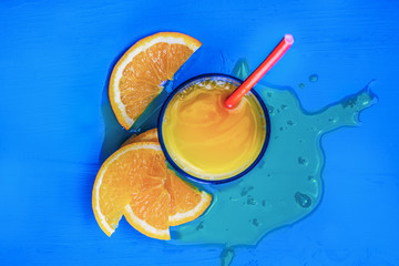 Glass of orange juice from above on vintage blue table. Empty ready for your orange juice, fruit product display or montage.
