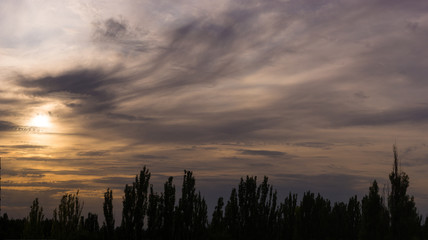 Landscape with dramatic light - beautiful golden sunset with saturated sky and clouds.