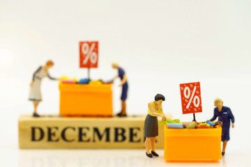 Miniatrue people: Shoppers buy goods on sale with discount tray. Tourism, shopping or business concept.