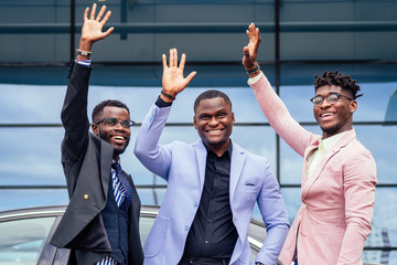 a group of their three successful African American businessmen in a stylish suit talking and...