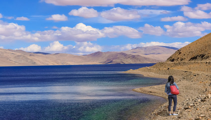 Fototapeta na wymiar Female tourist enjoy the scenic view at TSO Moriri lake Ladakh India.