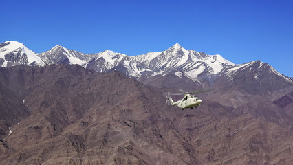 Tourist helicopter flies over the majestic Himalayas mountain range at Ladakh India.