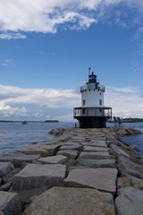 Fototapeta na wymiar Lighthouse at end of rock jetty