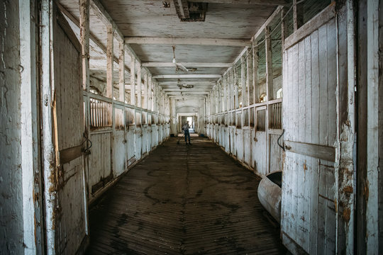 Inside old wooden stable or barn with horse boxes, tunnel or corridor view