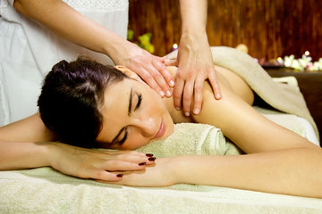 Fototapeta na wymiar Happy woman getting shoulder massage in spa happy relaxing frontal