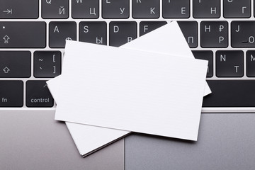 Blank business cards over laptop keyboard