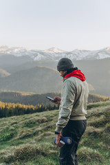 A man stands on the top and admires the mountains