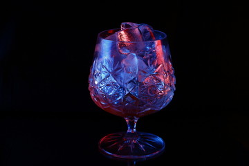 Ice in a glass with raspberry red and blue highlight.
