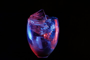 Ice in a glass with raspberry red and blue highlight.