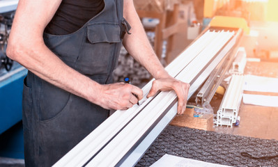 Production windows pvc, a man writes on the plastic profile dimensions, close-up, pvc, write a marker, arm
