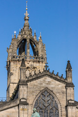 Edinburgh, Scotland, UK - June 13, 2012; St Giles Cathedral. Closeup of crowned spire against blue sky with white clouds. Gray stone structure.