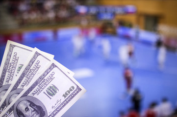 Money dollars on the background of a TV on which show handball, sports betting, money dollars and handball