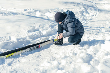 Boy teenager on skis in a park of winter snow drifts