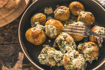 Swedish food - traditional chicken meatballs with cream sauce and new potatoes on a rustic wooden background, top view, copy space