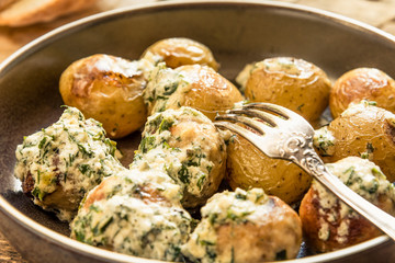 Swedish food - traditional chicken meatballs with cream sauce and new potatoes on a rustic wooden background, top view