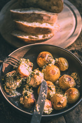 Swedish food - traditional chicken meatballs with cream sauce and new potatoes on a rustic wooden background, top view