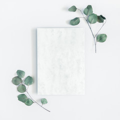 Marble paper blank, eucalyptus branches on pastel gray background. Flat lay, top view, copy space,...