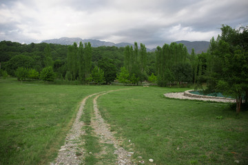 Majestic landscape of the mountains and forest in Caucasus at summer. Dramatic sky with clouds.