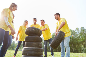 Junge Leute stapeln in Teamwork Autoreifen
