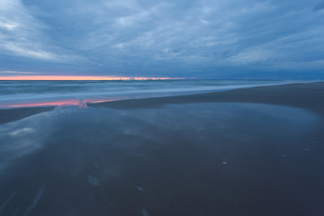 smooth sea surface and coast in blue twilight on long exposure