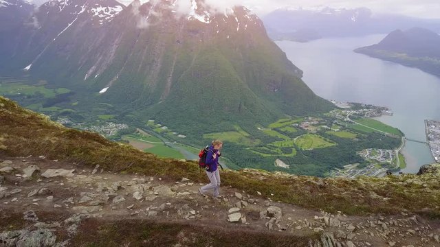 travel to Norway, aerial view of hiker with backpack walking in mountains, endurance sport