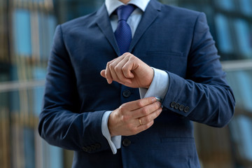 Elegant business man dress cufflinks on background with skyscrappers