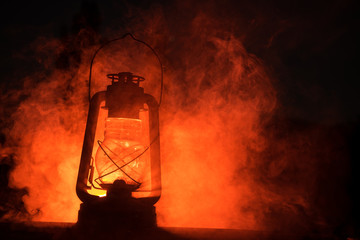 Fototapeta na wymiar Horror Halloween concept. Burning old oil lamp in forest at night. Night scenery of a nightmare scene.